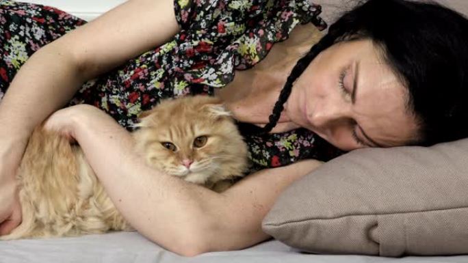 女人睡在她的猫旁边。视频