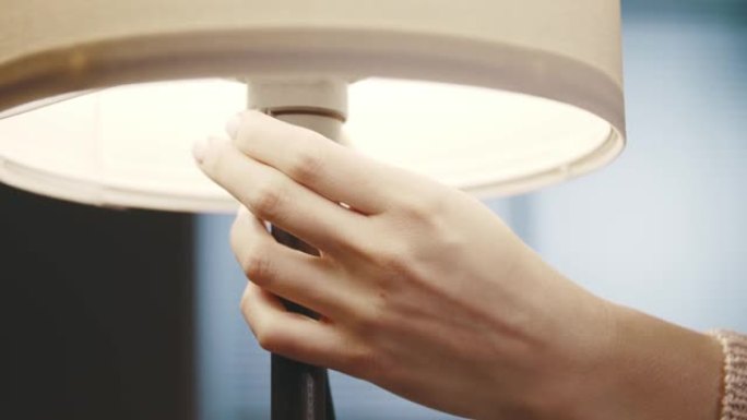 女人在家里打开台灯