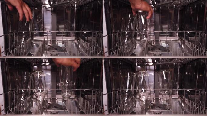 一名男子将玻璃瓶玻璃杯放在洗碗机的较低架子上