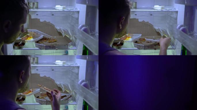 在冰箱里找食物的人。未刮胡子的人在冰箱里挖东西，他拿了一个披萨。