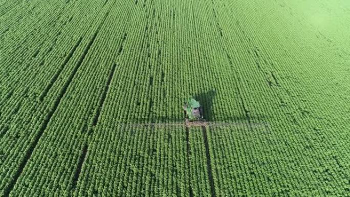 照顾庄稼。拖拉机在耕种的农田上施肥的鸟瞰图。