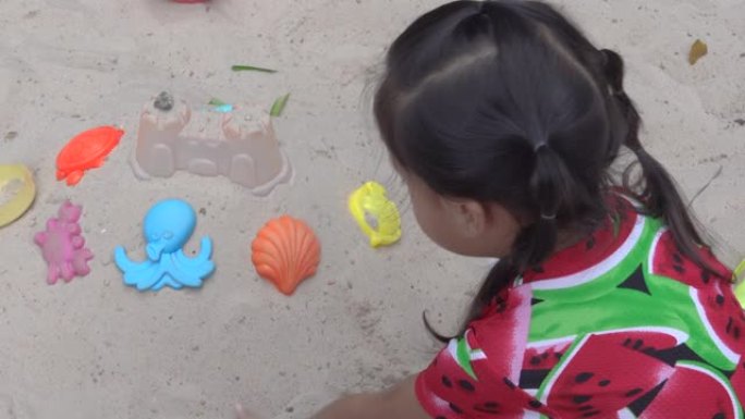 女婴喜欢玩沙子和玩具