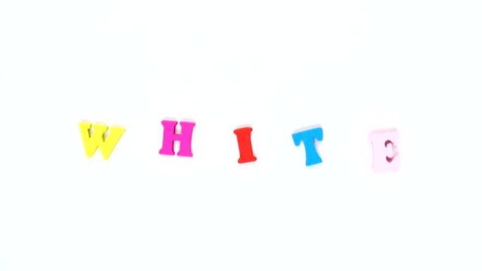 由木制五彩字母组成的单词 “白色”。五颜六色的单词循环。