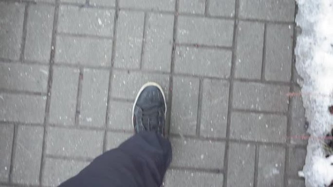 穿着黑色运动鞋的人走在人行道上，瓷砖在街上