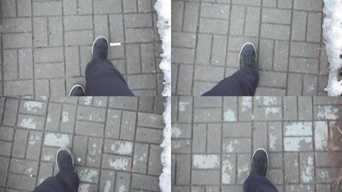 穿着黑色运动鞋的人走在人行道上，瓷砖在街上