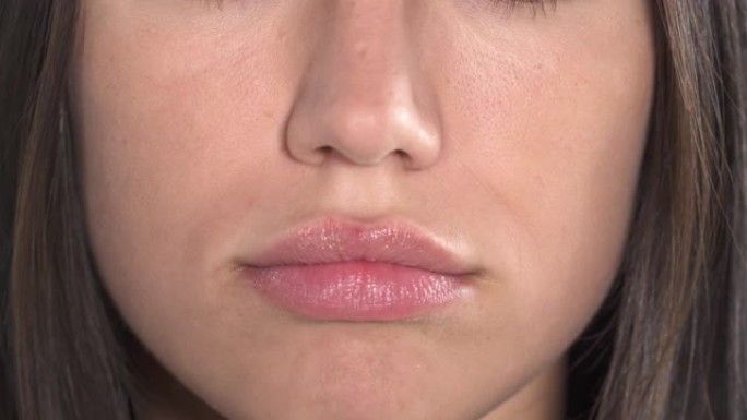 女性嘴唇的特写。女人在做有趣的面部鬼脸来表达伤害。真实情感概念