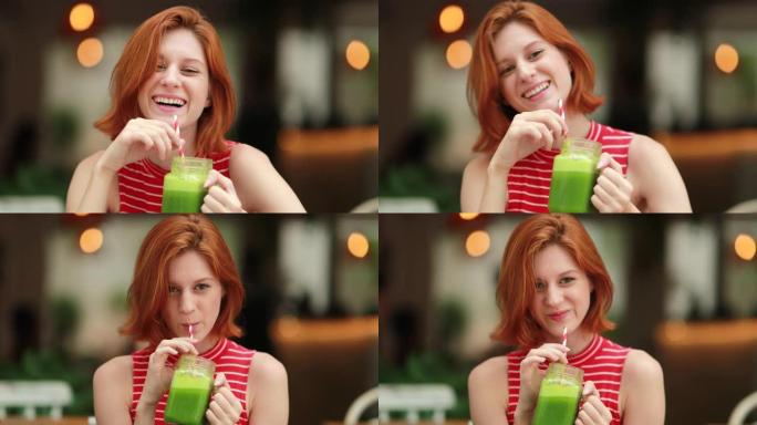 快乐红发女孩喝排毒绿汁微笑着笑