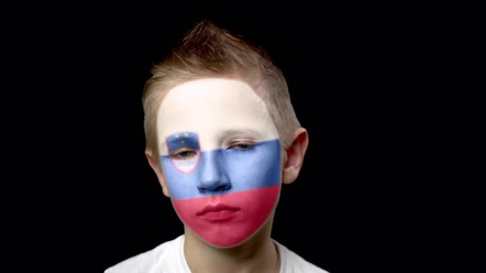 斯洛文尼亚足球队的悲伤球迷。脸上涂着民族色彩的孩子。