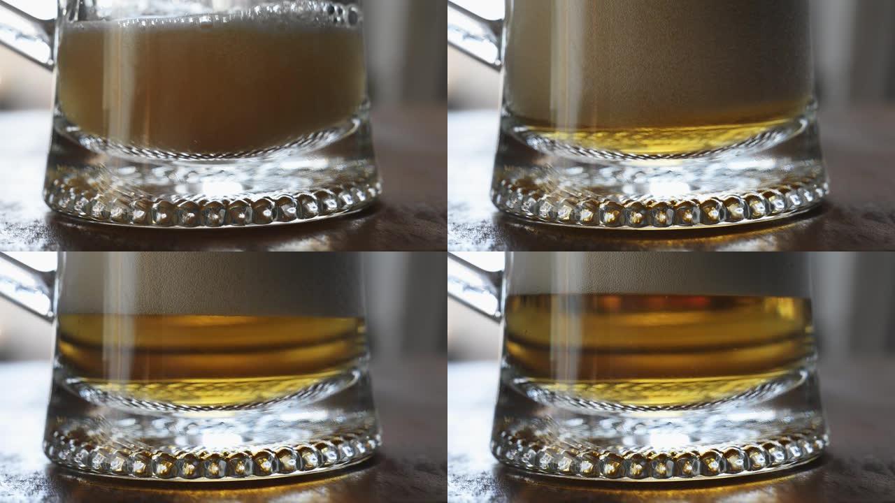 特写啤酒倒入透明玻璃杯中，泡沫变成啤酒