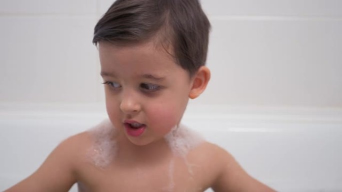 留着黑胡子的小男孩坐在浴室里