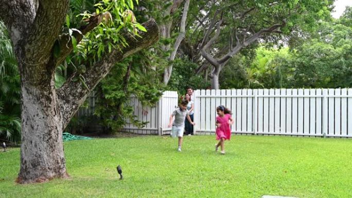 西班牙裔儿童与父母一起跑进花园