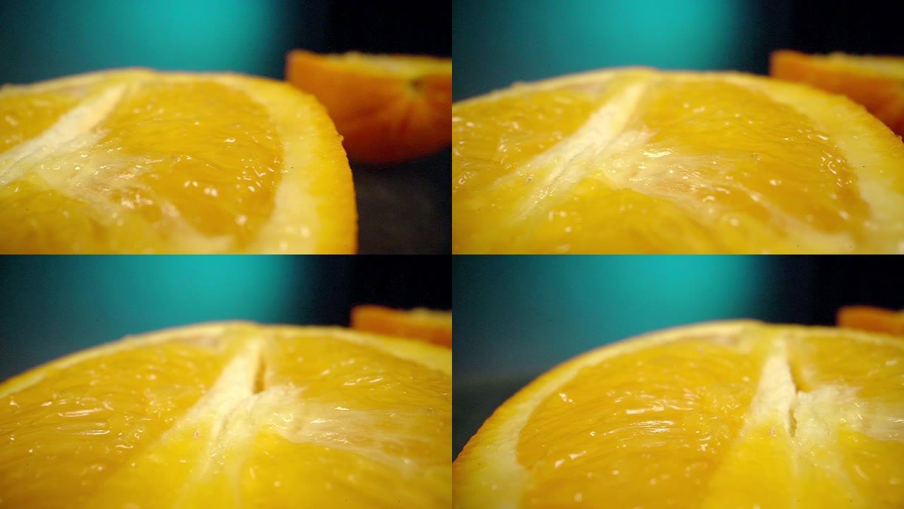 在工作室里，在黑暗的厨房台面上，将新鲜的当季成熟的橙色切成两半的特写镜头