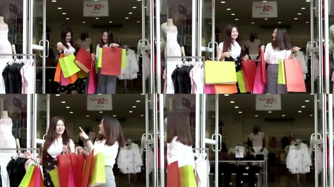 销售当天，两个美丽的亚洲年轻女性带着购物袋在购物中心疯狂