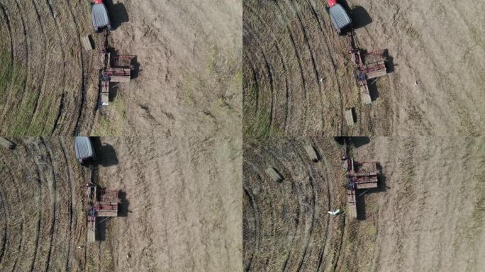 鸟瞰农场工人携带圆形圆柱形稻草堆，农田