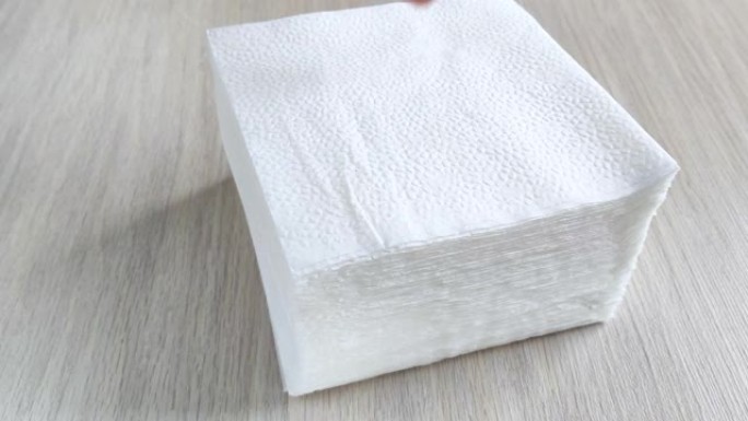 木桌上的一堆白色方形餐巾纸