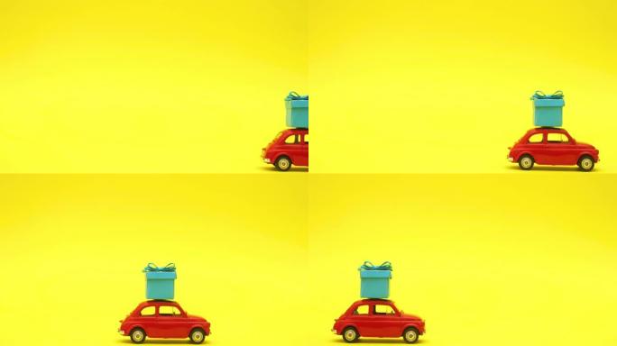 红色复古汽车驾驶蓝色礼物在屋顶上黄色背景-停止运动