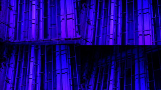 夜色紫光下的神秘窗户。窗户上的酒吧