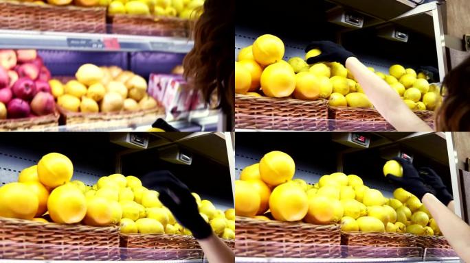 近距离的女工人在黑色手套stocking在超市的柠檬。年轻员工在工作。卷曲的女性安排在架子上的柠檬。