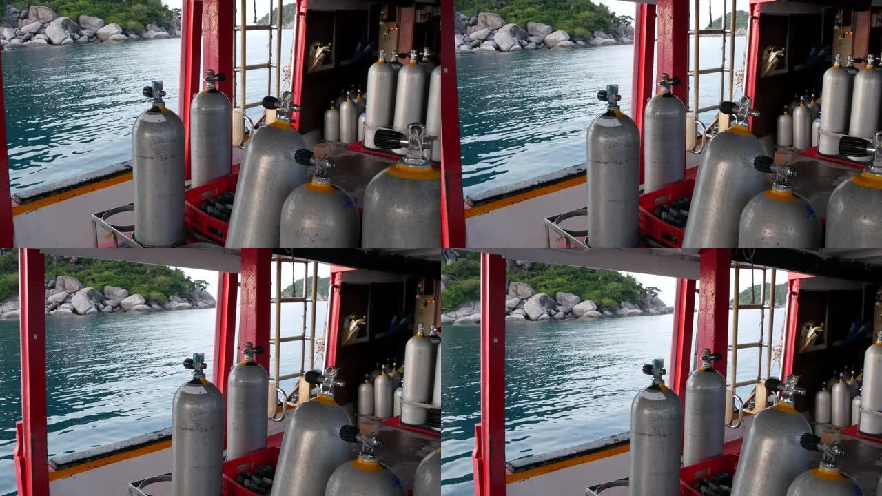 一排氧气罐和潜水设备放在泰国Koh Tao resort附近荡漾的海洋中的现代船上。旅游运动的概念极