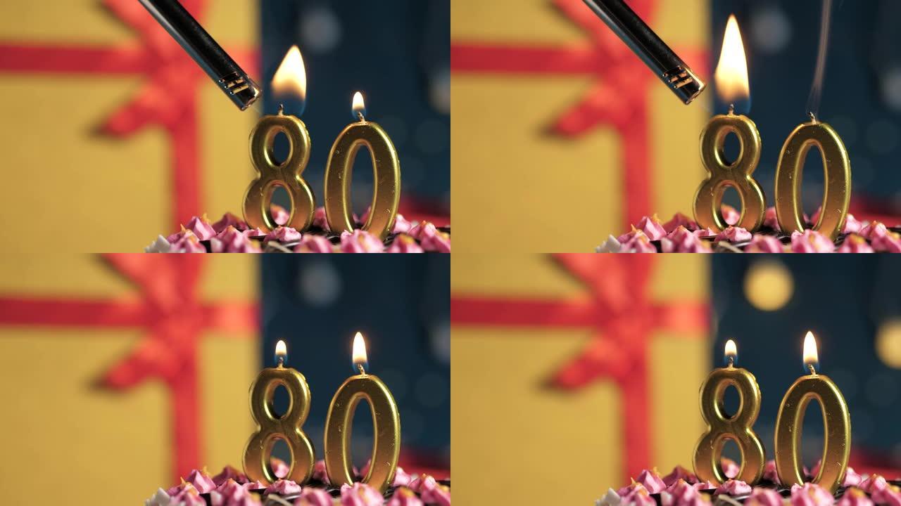 生日蛋糕80号点火器燃烧的金色蜡烛，蓝色背景礼物黄色盒子用红丝带绑起来。特写和慢动作