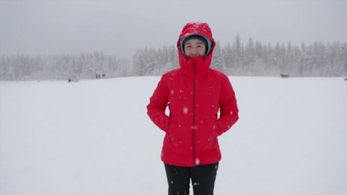 年轻的亚洲妇女在白雪皑皑的公园玩得开心