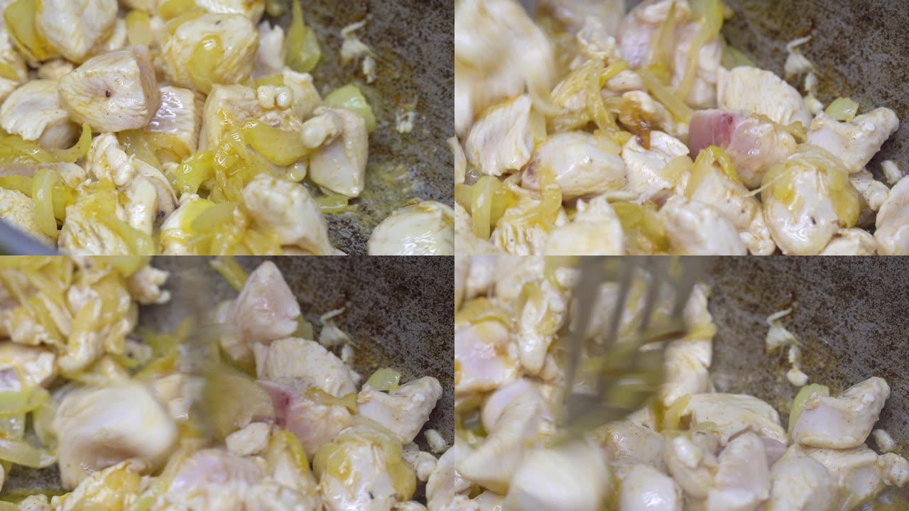 炸洋葱和鸡片在平底锅里炸。塔斯基的阿祖。烹饪。
