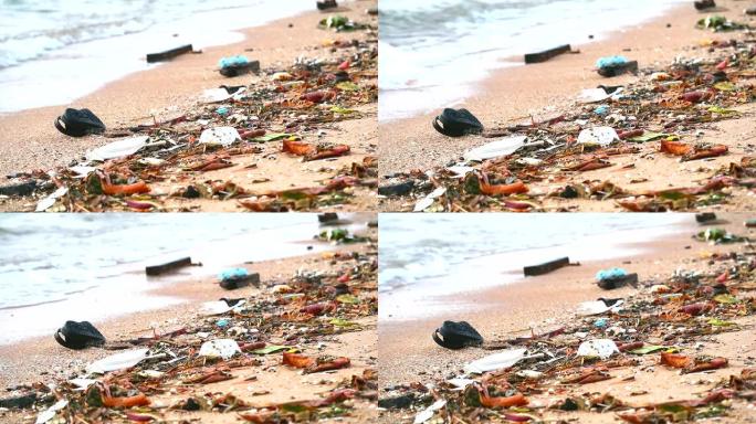 海滩上的日落用塑料橡胶和废物留在海滩上，海浪把它们吹入海中