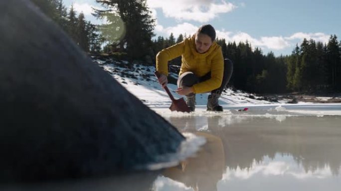 打破僵局。勇敢的女游客站在冰冻的湖面上。