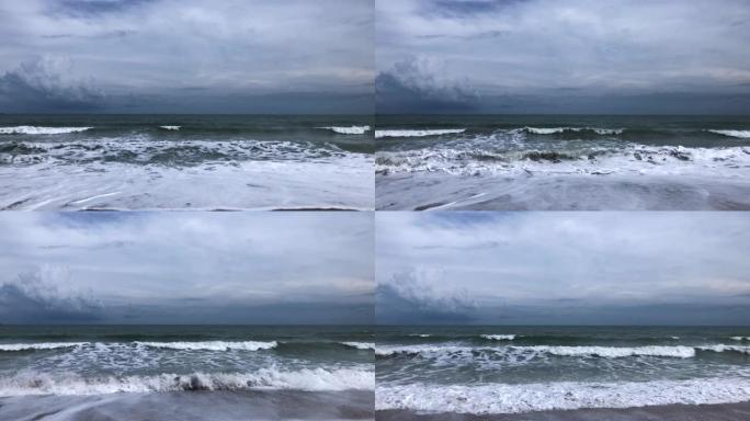 海浪袭击热带沙滩，天空多云