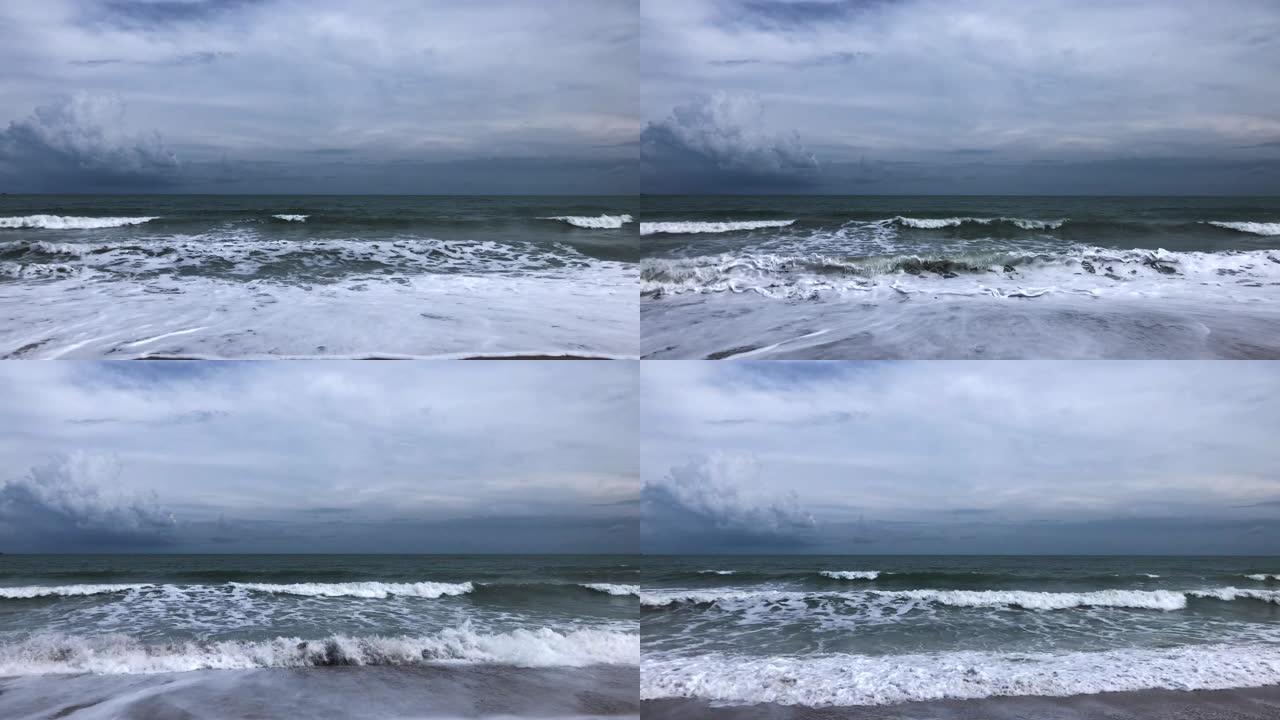海浪袭击热带沙滩，天空多云