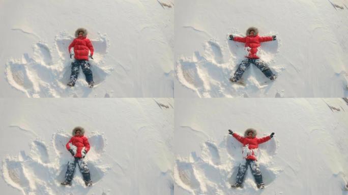 一个小男孩做了一个雪天使。冬季娱乐概念。慢动作镜头