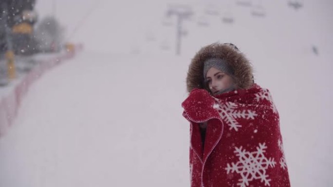 暴风雪中裹着毯子的冷冻女人的特写
