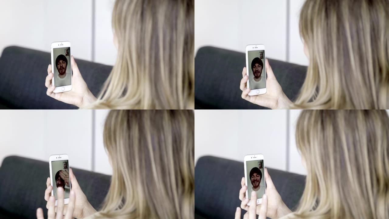 年轻女子与丈夫进行视频通话的背面视图。