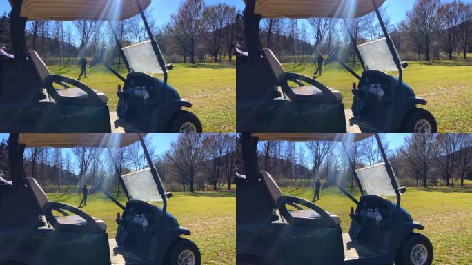 高尔夫球手用高尔夫球车用阳光击中高尔夫球场上的高尔夫球