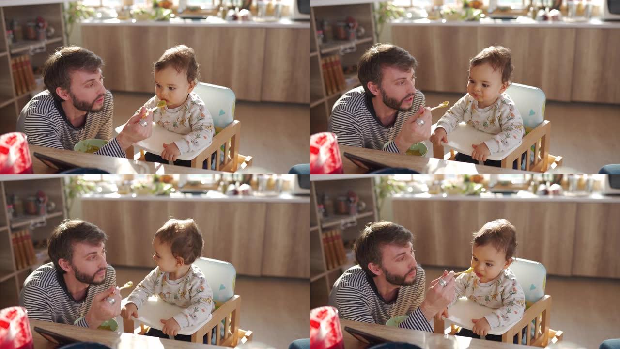 年轻的父亲在家喂养他的小儿子