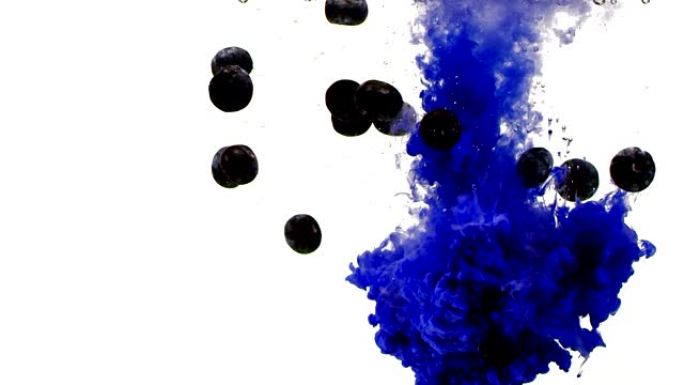 彩色蓝色墨水，在水中扩散并掉落蓝莓/彩色烟雾，以慢动作从上到下擦拭框架。孤立在黑色背景上。特写视图。