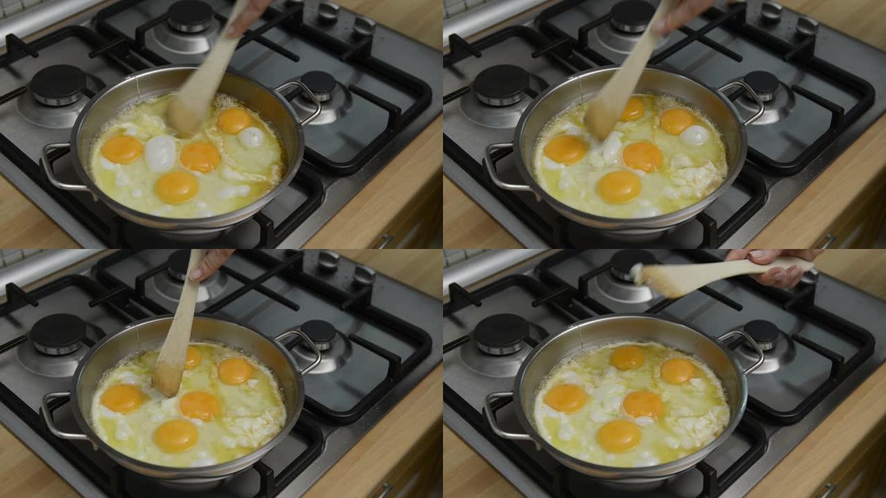 家庭主妇在钢锅中融化黄油以煎鸡蛋