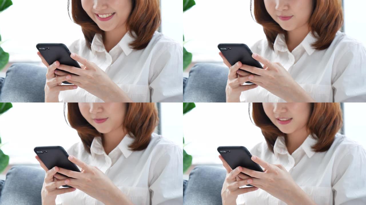 亚洲女性在智能手机上使用ipad购物在线网站，面带微笑。幸福亚洲妇女拿着手机检查来自在线购物网站的邮
