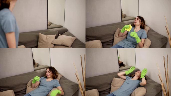 虚弱的年轻女子打扫后倒在沙发上，洗木地板后感到疲倦。呼气。戴着绿色橡胶手套。慢动作
