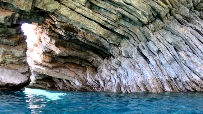 洞穴中的层状岩石和明亮清澈的海水