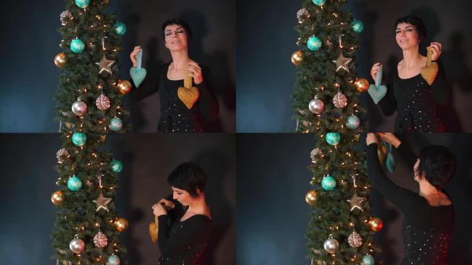 一个穿着黑色连衣裙的女人用圣诞玩具装饰圣诞树。