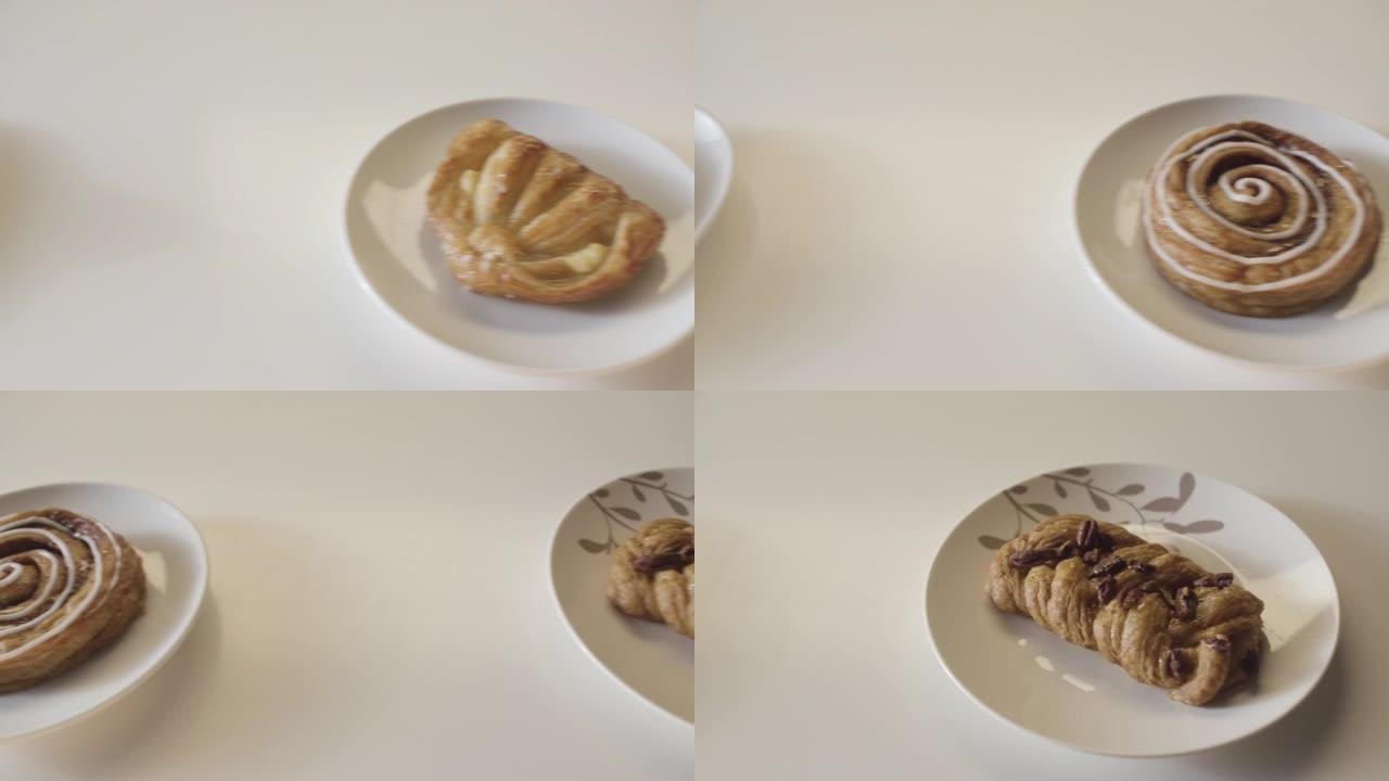 几盘美味的糕点产品排成一排放在木桌上。库存镜头。白色桌子背景上美味面包产品的特写