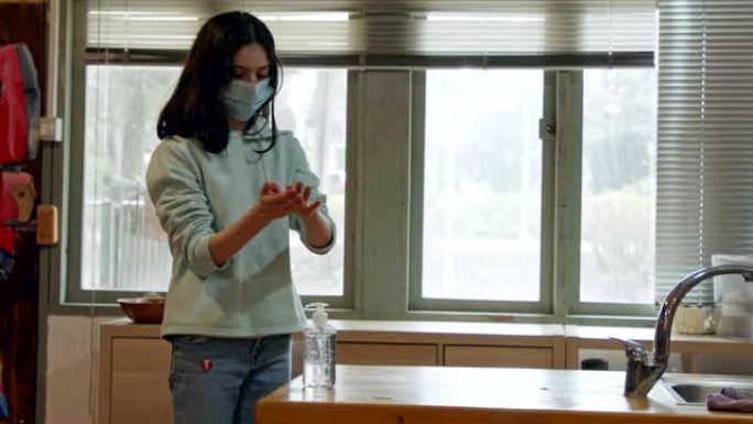 电晕大流行 -- 戴口罩的女孩使用洗手液防止冠状病毒