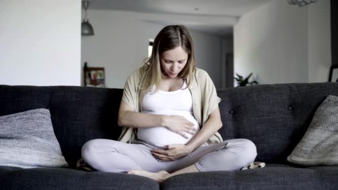 孕妇揉肚子和婴儿说话的前视图