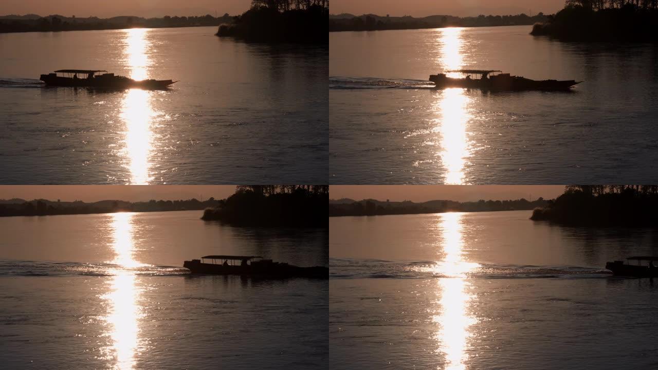 在美丽的日落时航行的木船的轮廓。