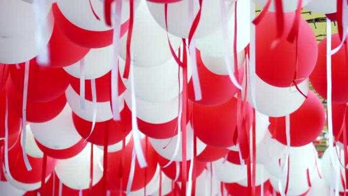 红色和白色的气球悬挂在天花板上庆祝。