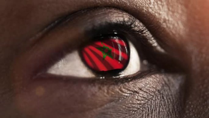 女人黑眼睛在近距离与旗帜摩洛哥鸢尾花与风的运动。视频的概念