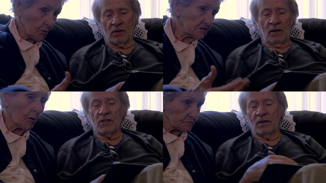 两名年迈的老年人拿着移动平板电脑聊天-多莉射击