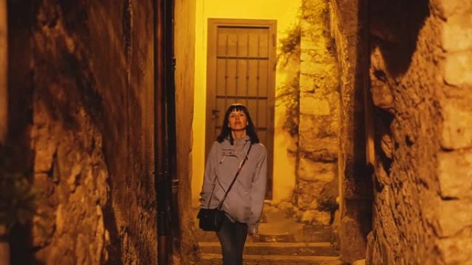 旅程。一个女孩走过特拉西纳的夜城。意大利。