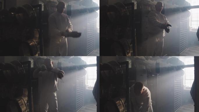 一名击剑运动员在有雾的设备室内戴上击剑手套和面罩